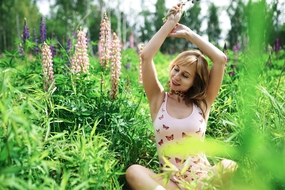 欧美美女坐在花草丛中伸懒腰图片